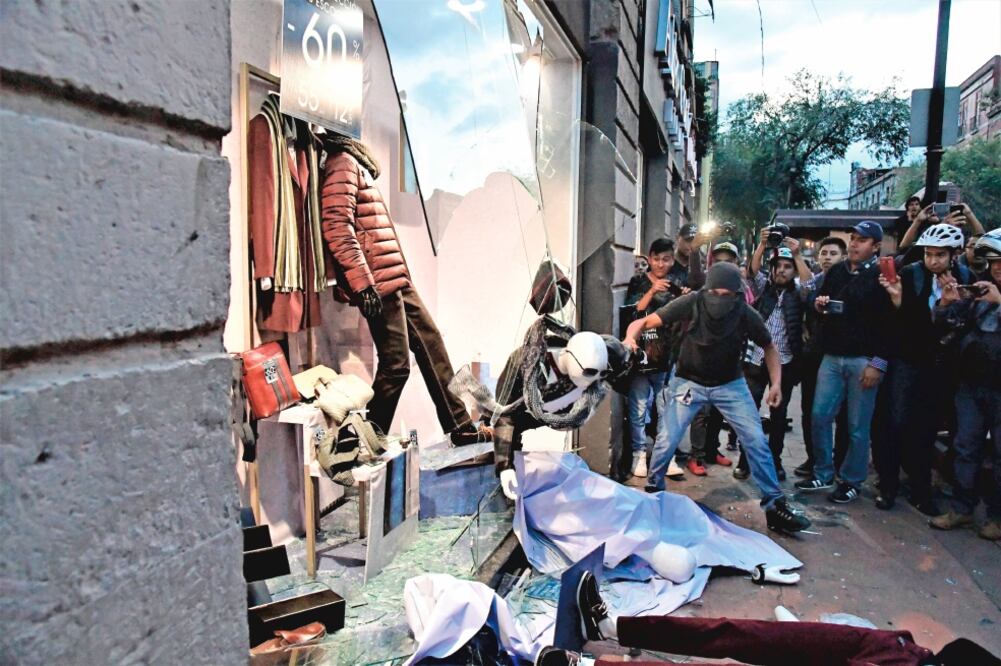 Personas encapuchadas irrumpieron en una tienda de ropa del Centro Histórico, saquearon parte de la mercancía y otras prendas quedaron regadas en el piso. Foto: FRANCISCO RODRÍGUEZ. EL UNIVERSAL