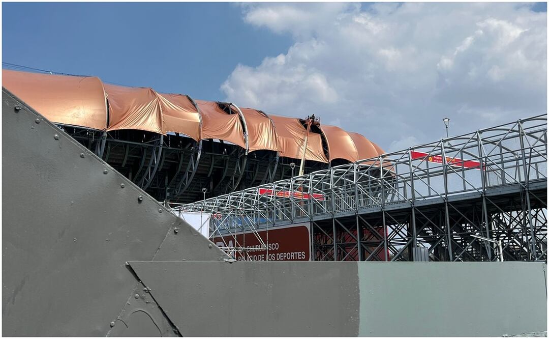 En el Estadio GNP Seguros que da hacia Río Churubusco, cuatro personas maniobran una de las lonas naranjas apoyados de una grúa de elevación de al menos 20 metros de altura. Foto: Especial