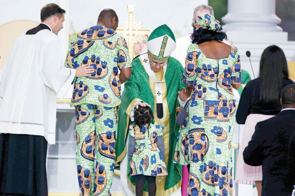 El papa Francisco toca la cabeza de una niña que se acercó a él, al término de la última misa que celebró en el Festival de las Familias, en Filadelfia (JIM BOURG. REUTERS)