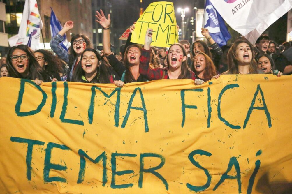 Brasileñas corean eslóganes y muestran un cartel que dice: Dilma se queda, Temer se va, durante una protesta ayer en Sao Paulo contra el gobierno interino (NACHO DOCE. REUTERS)
