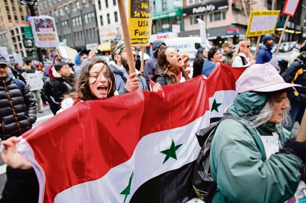 Manifestantes con pancartas y banderas de Siria participaron ayer en la protesta antiguerra, en la ciudad de Nueva York, Estados Unidos. Foto: KENA BETANCUR. AFP
