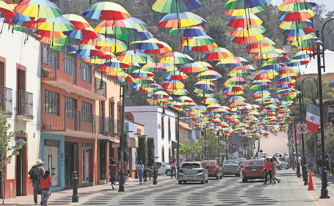 La instalación de sombrillas flotantes que llenan de color la calle Miguel Hidalgo en este Pueblo Mágico, han reactivado el turismo; las ventas de los locatarios se han incrementado en 70%. Foto: Jorge Alvarado/EL UNIVERSAL