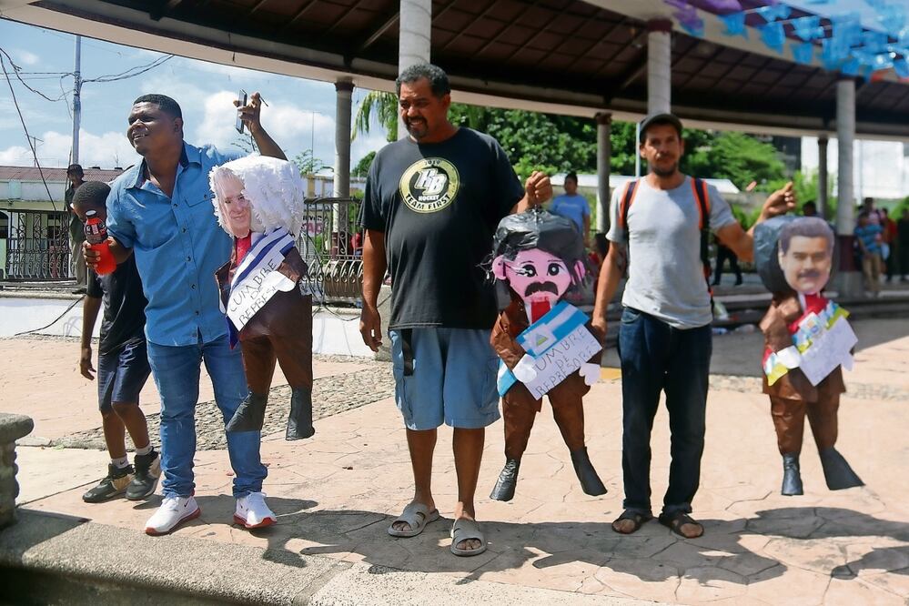 Migrantes con piñatas con los rostros de los presidentes de Cuba, Miguel Díaz-Canel; de Nicaragua, Daniel Ortega, y de Venezuela, Nicolás Maduro, en la ciudad mexicana de Tapachula, Chiapas. Foto: Juan Manuel Blanco / EFE