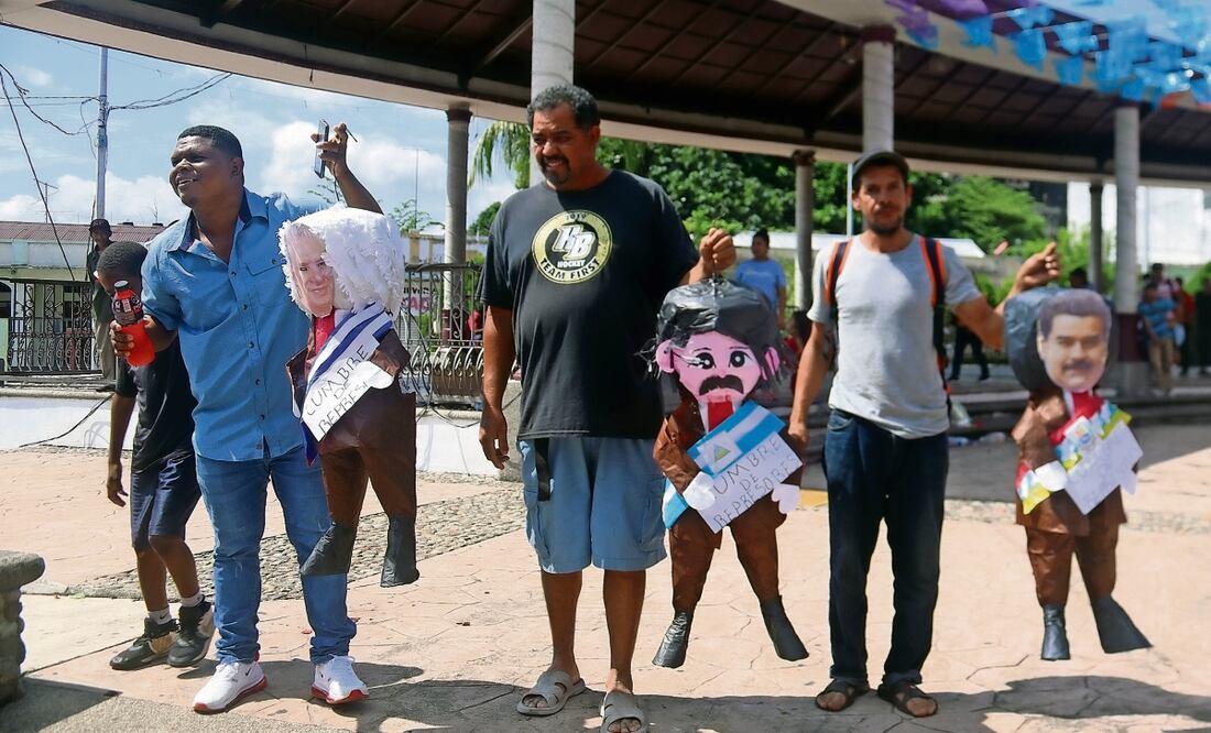 Migrantes con piñatas con los rostros de los presidentes de Cuba, Miguel Díaz-Canel; de Nicaragua, Daniel Ortega, y de Venezuela, Nicolás Maduro, en la ciudad mexicana de Tapachula, Chiapas. Foto: Juan Manuel Blanco / EFE