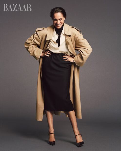 Meghan apuesta por un clásico trench beige, camisa blanca y falda negra, un estilismo elegante y atemporal. Foto: Harper’s Bazaar (Malick Bodian)