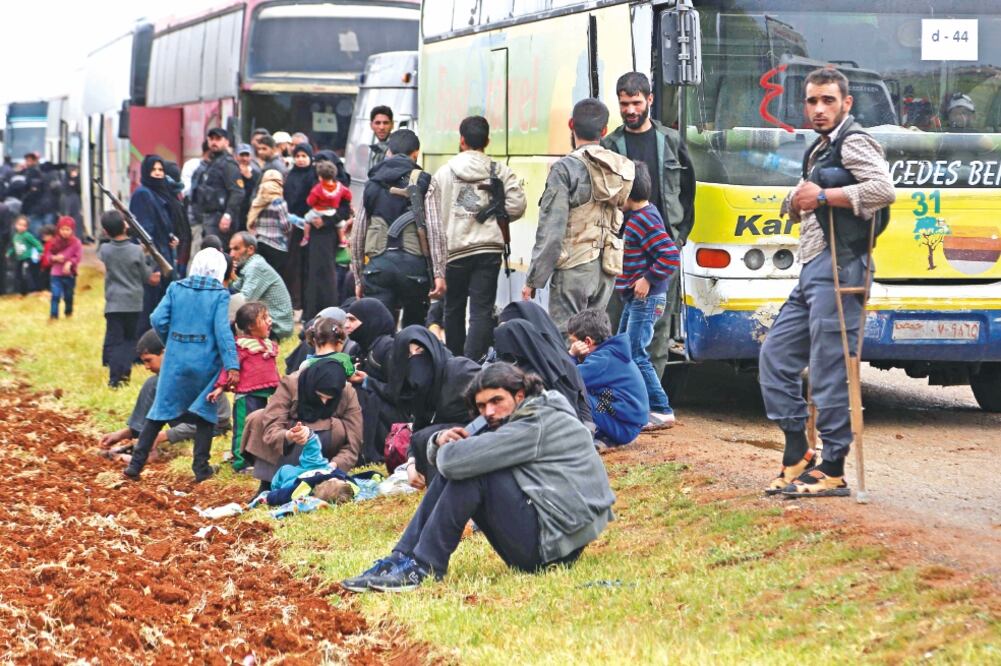 Rebeldes sirios y sus familias se preparan para huir de Duma, donde el sábado se registró un supuesto ataque químico del que Washington responsabiliza al régimen de Bashar al-Assad. (NAZEER AL-KHATIB. AFP)