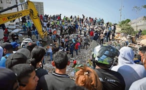 Equipos de rescate, voluntarios y residentes se reúnen alrededor de una excavadora mientras buscan entre los escombros de edificios colapsados en
Catia La Mar, La Guaira. Foto: Federico Parra / AFP