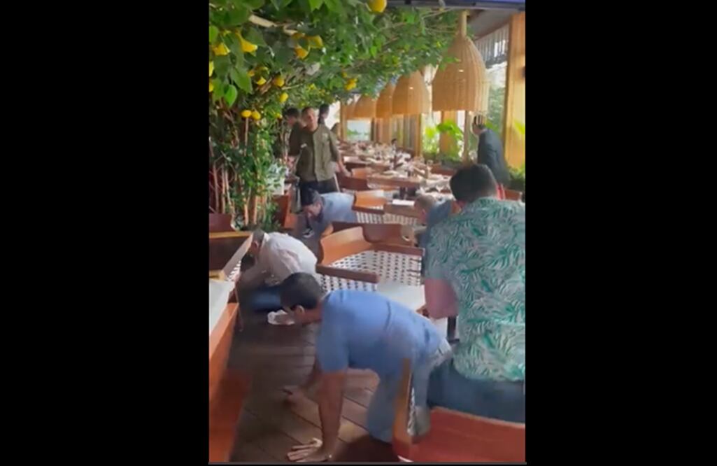 FOTO: captura tomada de Twitter @BalaceraZMG /EL UNIVERSAL/En la imagen se observa al mesero (de camisa verde) pidiendo a los comensales se agachen y a gatas se resguarden en la parte de en medio del local