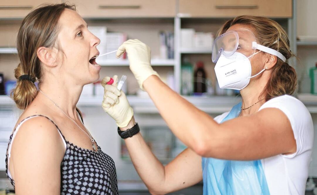 Una doctora realiza una prueba para saber si una joven tiene Covid-19, en Kamp-Lintfort, Alemania. Foto: FRIEDEMANN VOGEL. EFE