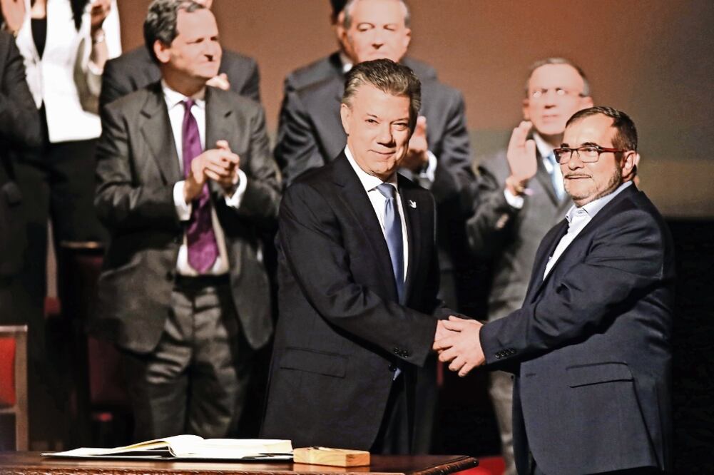 El presidente de Colombia, Juan Manuel Santos, y el jefe de las FARC, Rodrigo Londoño, durante la ceremonia del nuevo acuerdo de paz entre el gobierno y le guerrilla, el pasado 24 de noviembre (ARCHIVO EL UNIVERSAL)