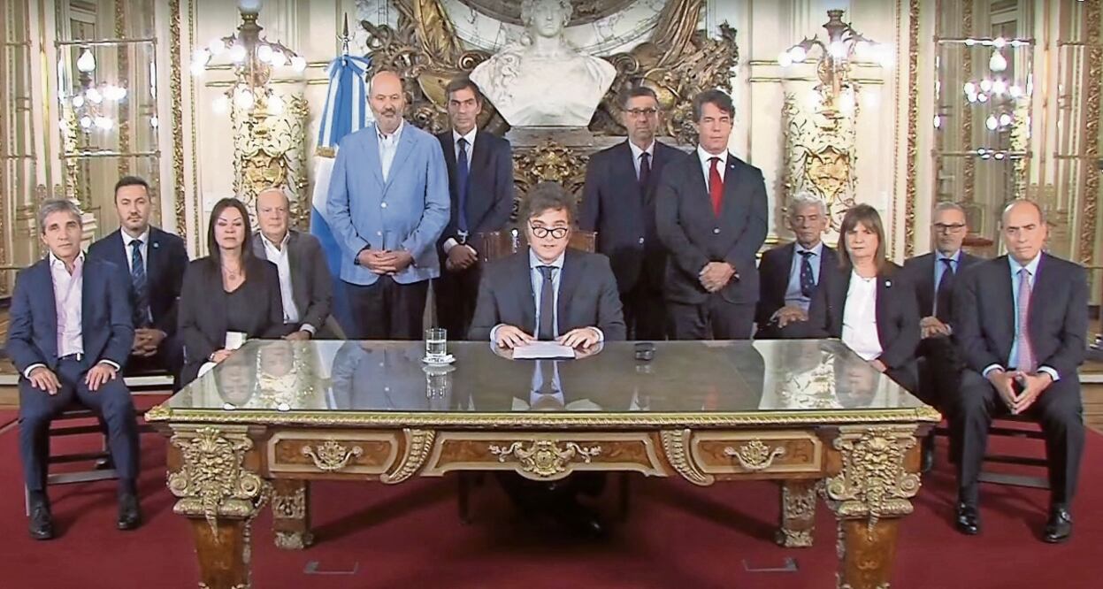 El presidente Javier Milei (al centro) con su gabinete, en su mensaje a la nación del miércoles donde anunció un decreto de desregulación. Foto: AFP