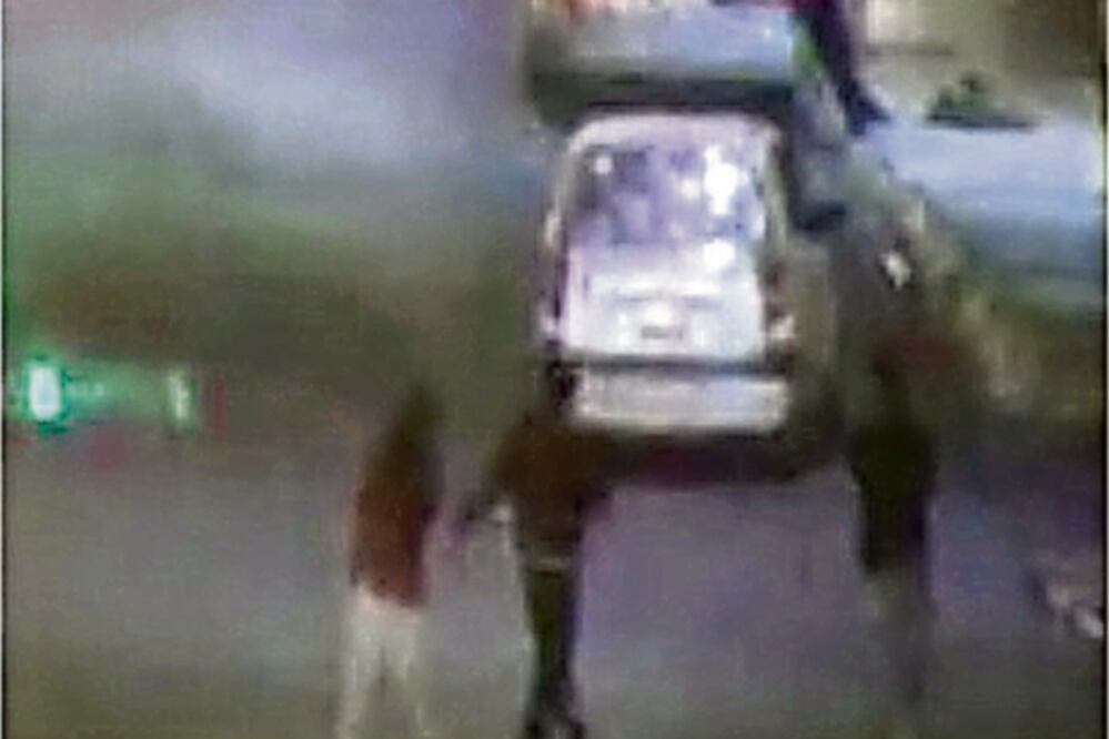 En una fotografía se observa cuando la víctima (rojo) y los presuntos homicidas suben al automóvil en Nezahualcóyotl. (ESPECIAL)