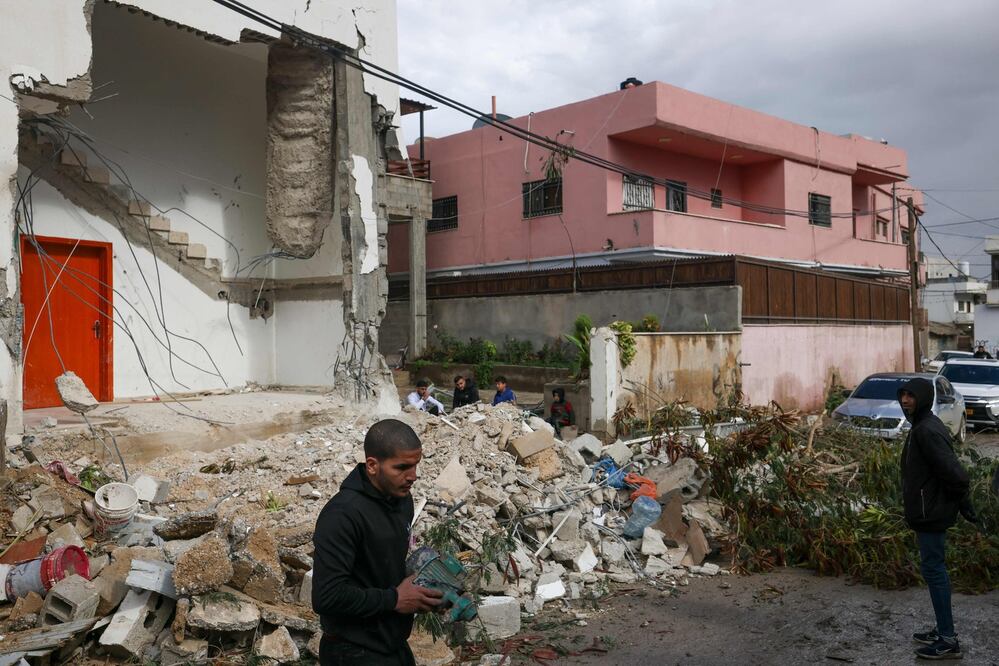 Palestinos inspeccionan una casa dañada luego de una redada en el campo de refugiados en la ciudad de Jericó. Foto: AFP