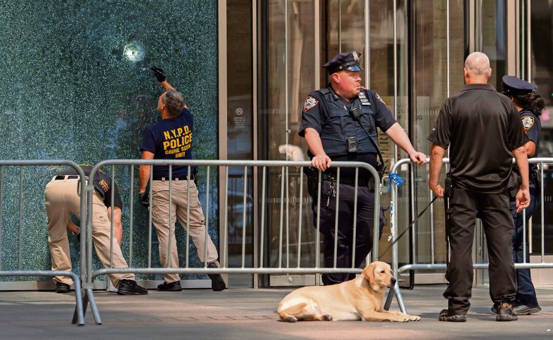 Miembros de la Unidad de Delitos del Departamento de Policía de Nueva York examinan una puerta con impactos de bala tras el tiroteo en la ciudad. Foto: Yuki Iwamura / AP