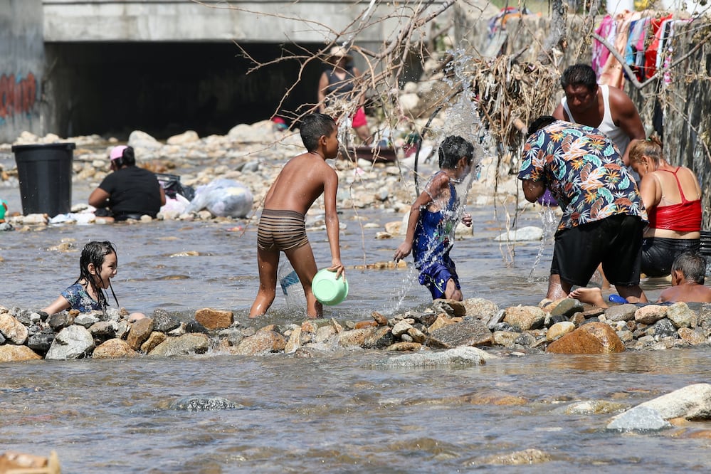 Ante la escasez de agua en el puerto de Acapulco, decenas de personas llegan al río que atraviesa la colonia Caravana —por el que normalmente corren aguas negras— para bañarse y lavar su ropa. Foto: Valente Rosas / EL UNIVERSAL