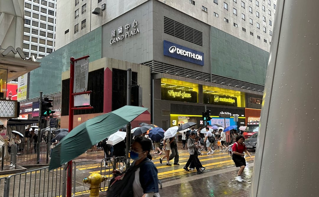 Peatones caminan haciendo frente a la lluvia y el viento en Hong Kong antes de la llegada del tifón Noul. Foto: AP