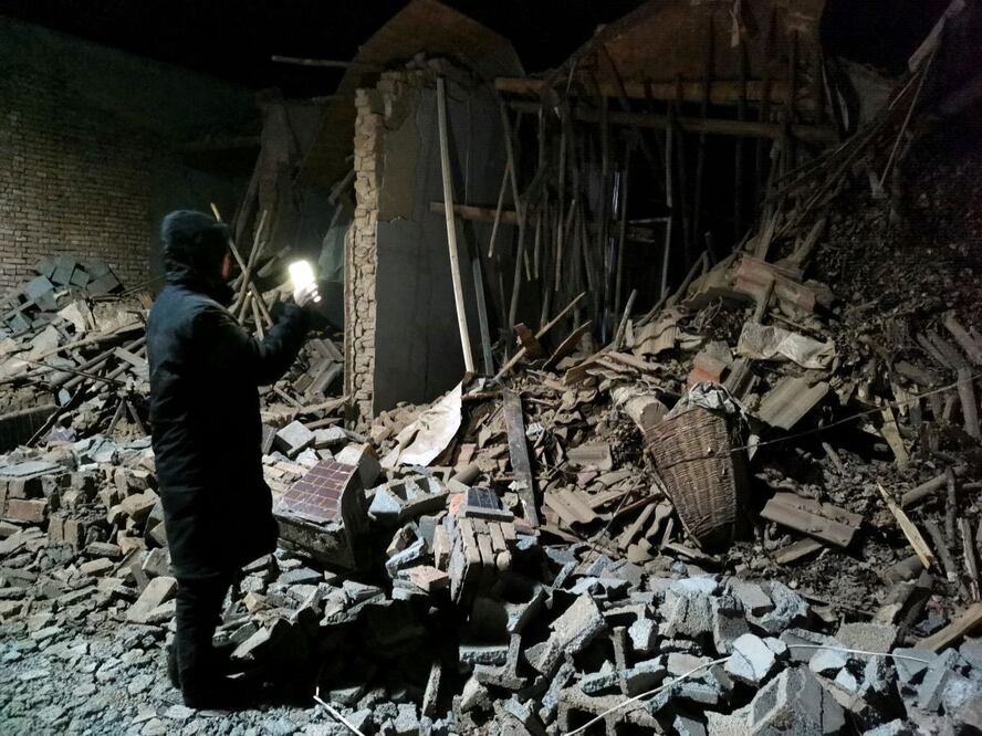 Un empleado de gobierno revisa los escombros de una casa que se vino a bajo tras un terremoto en el condado de Jishishan, en la provincia china de Gansu. AP