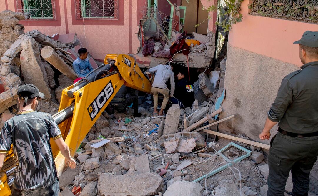 La gente busca entre los escombros de un edificio dañado con la ayuda de una excavadora después de un terremoto en Marrakech, Marruecos. Foto: EFE