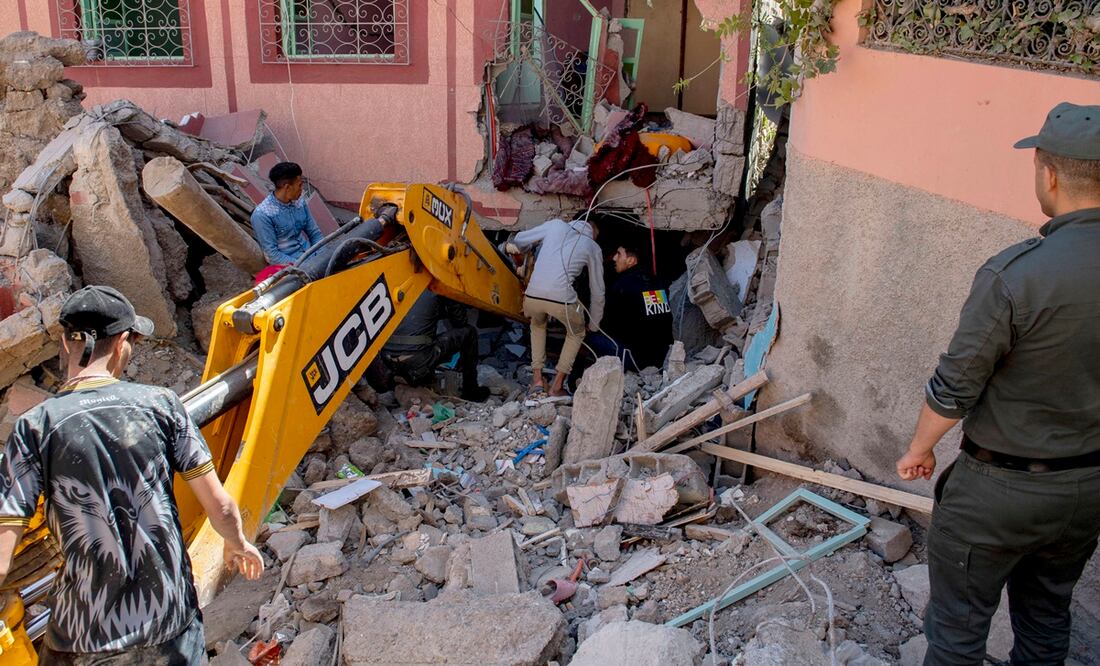 La gente busca entre los escombros de un edificio dañado con la ayuda de una excavadora después de un terremoto en Marrakech, Marruecos. Foto: EFE