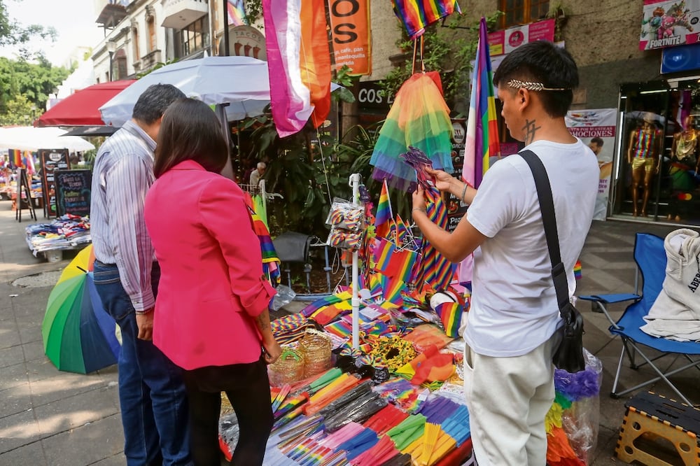 Comerciantes de la Zona Rosa ofrecen productos como la bandera de la comunidad, diademas y coronas, previo a la celebración de la Marcha del Orgullo LGBT+. Foto: de Luis Camacho. El Universal