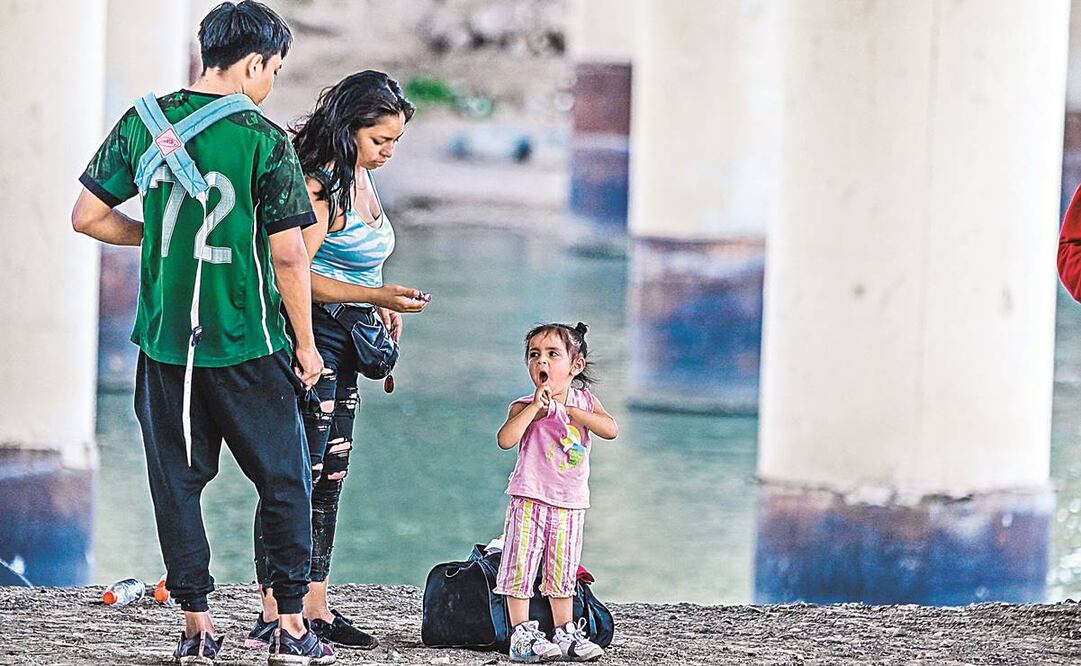 Una familia de migrantes espera que la Patrulla Fronteriza les diga cuál será su destino, en Eagle Pass, Texas. Foto: Chandan Khanna/ AFP.