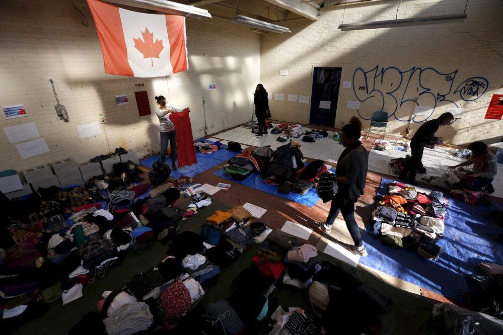 Ropa donada para la afluencia esperada de refugiados sirios es ordenada por voluntarios en una sala de ensayo de teatro en Toronto. (Foto: Reuters)