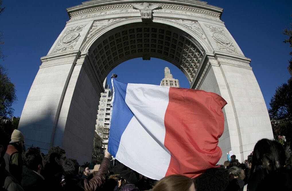 Una bandera francesa es agitada durante la vigilia que se lleva a cabo en Square Park en Nueva York, EU