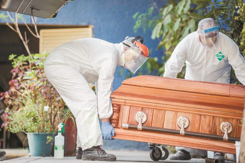 En la imagen, empleados de una funeraria en Xochimilco atienden las recomendaciones de las autoridades sanitarias, que presentaron el protocolo para el manejo de cadáveres por el coronavirus. Foto: PEDRO PARDO. AFP