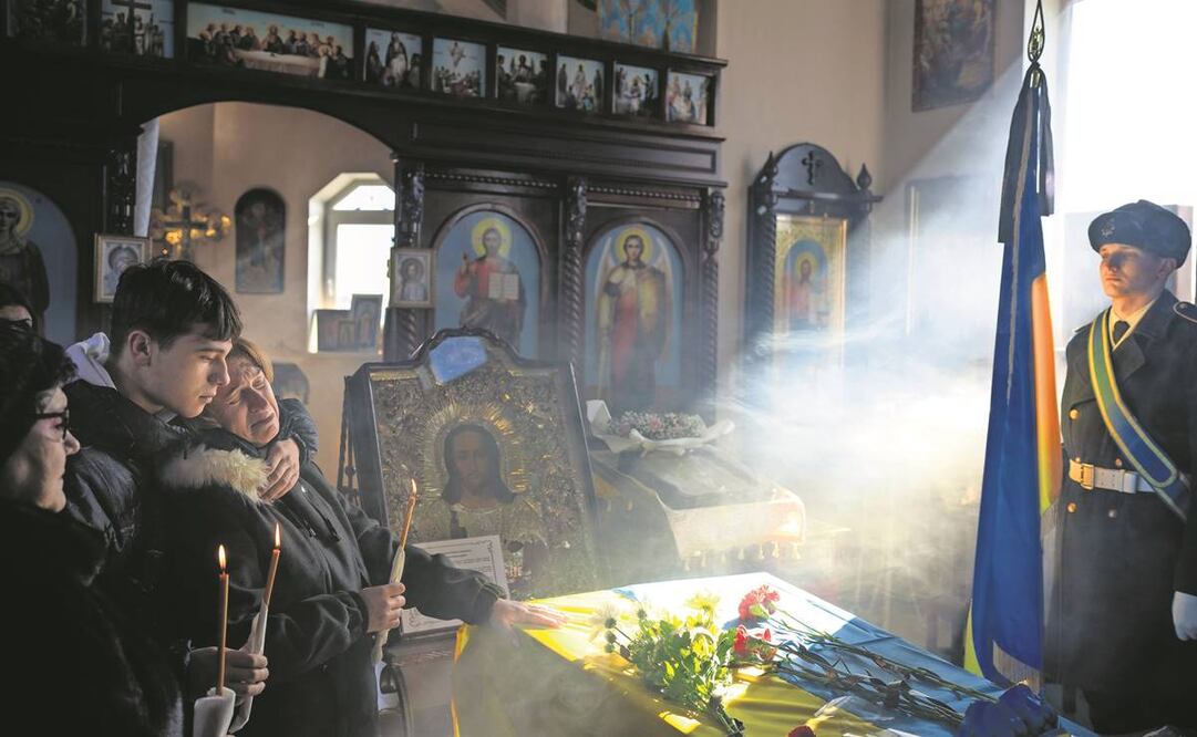 Svitlana con su hijo Kyrylo, junto al ataúd de su esposo Serhii, de 48 años, durante su funeral en la aldea de Tarasivka, cerca de Kiev.