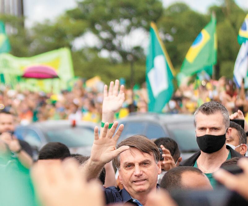 El presidente de Brasil, Jair Bolsonaro (saludando), se reúne con simpatizantes en la capital, sin protección contra el Covid-19. Foto: JOÉDSON ALVES. EFE