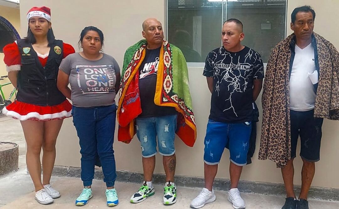 Cuatro presuntos vendedores minoristas de cocaína arrestados en un distrito comercial, escoltados por agentes de la policía peruana. Foto: AFP