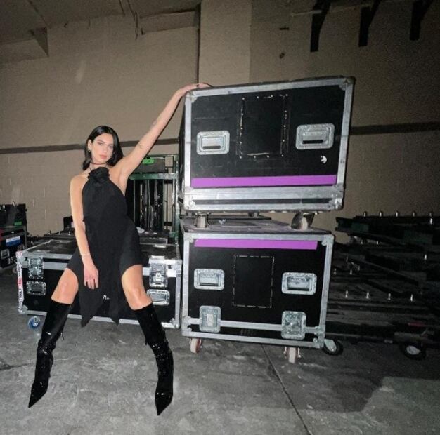 Dua Lipa luce increíble con minivestido negro y botas altas de charol