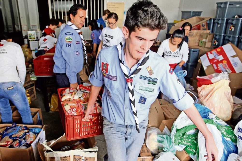 Miembros de la Cruz Roja de Colombia organizan las ayudas recibidas en los centros de acopio para los damnificados por la avalancha en Mocoa. (MAURICIO DUEÑAS. EFE)