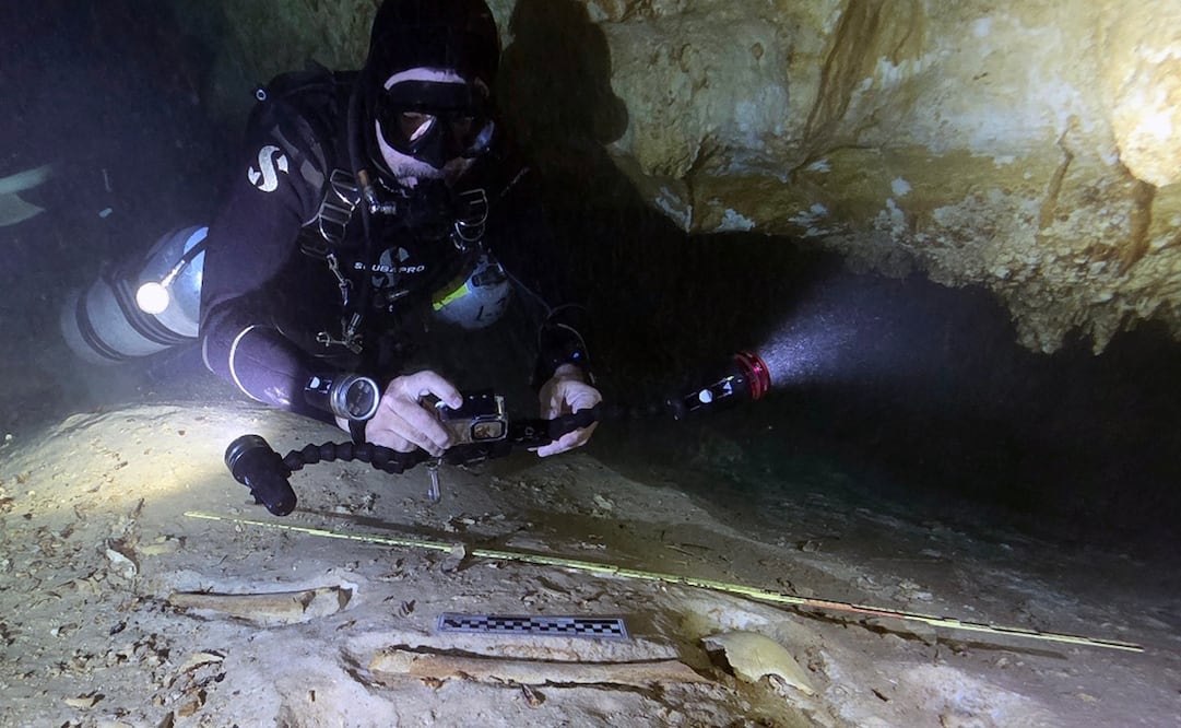 El arqueólogo submarino Octavio del Río fotografía los restos de un esqueleto humano prehistórico. Foto: Eugenio Acevez/INAH vía A.