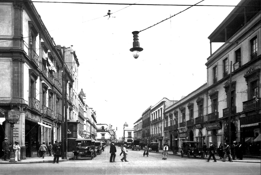 La calle de Gante, vista desde la esquina con 16 de Septiembre alrededor de 1920. Casi al centro se aprecia el remate del templo de la Iglesia Metodista de México, abierto en 1873, inmueble que antiguamente fue el claustro del Convento de San Francisco. Desde la década de los setenta, esta calle permanece cerrada al tráfico vehicular. Col. Villasana-Torres 