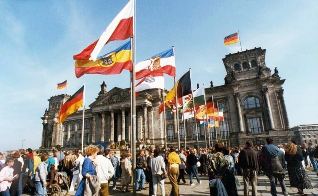 Para el 3 de octubre de 1990, las banderas de los 16 estados federados ondearon frente al Reichstag por primera vez, lideradas por la bandera oficial alemana. Se convocó a elecciones federales para elegir al nuevo parlamento que representara al territorio reunificado. Foto: German Federal Archive/Wikimedia Commons.