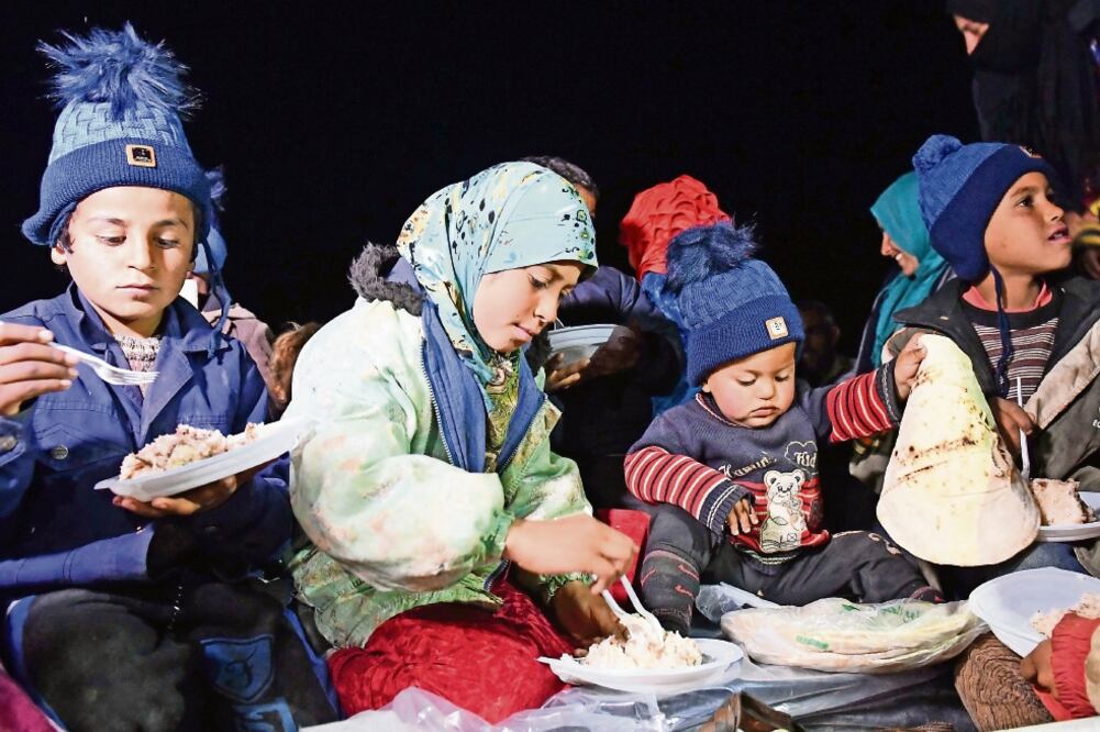 Apoyo. Sirios que han huido de sus hogares reciben ayuda de las fuerzas rusas en Abu al-Duhur (GEORGE OURFALIAN. AFP)