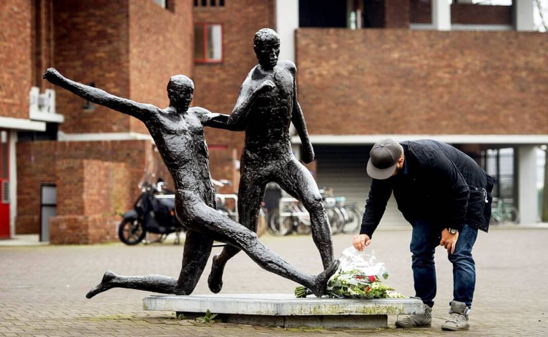 Un hombre deposita flores en la estatua de Johan Cruyff en el estadio Olímpico de Amsterdam (Foto: EFE)