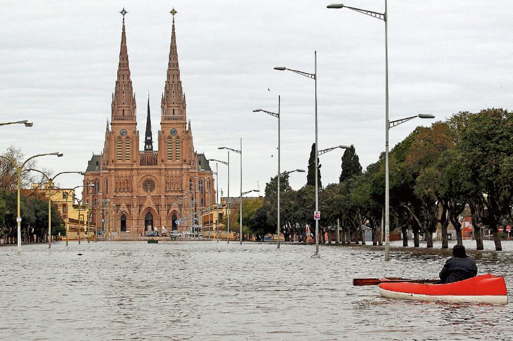 Un argentino se traslada en un bote por una calle inundada, frente a la Basílica de Luján. Más de 20 mil personas han sido desalojadas, debido a las intensas lluvias que azotan Buenos Aires desde hace días (MARCOS BRINDICCI. REUTERS)