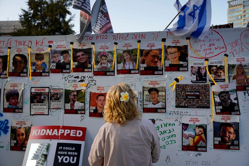 Una mujer mira fotografías de rehenes, en su mayoría civiles israelíes, que fueron secuestrados durante el ataque de Hamas contra Israel el 7 de octubre. Foto: AP
