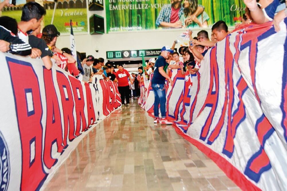 La afición le hizo pasillo al campeón Guadalajara, a su llegada al AICM. (TWITTER)