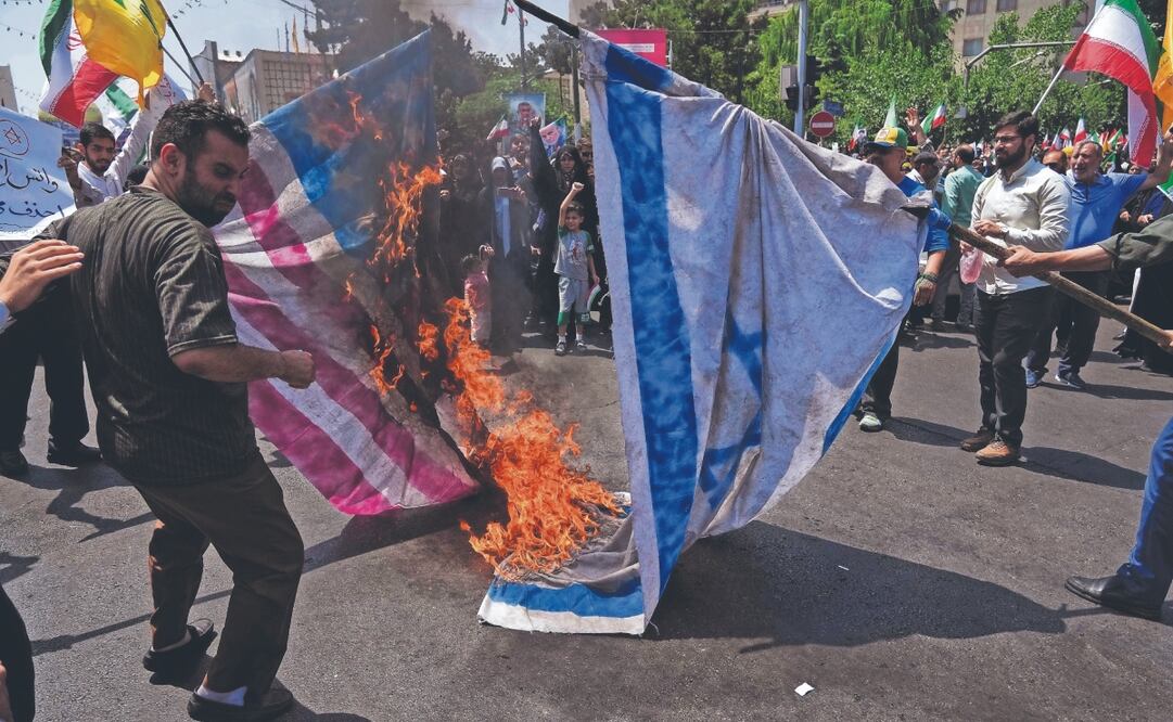 Manifestantes iraníes, ayer al quemar representaciones de las banderas de Israel y Estados Unidos durante una protesta para condenar los ataques israelíes en Teherán. Foto: de Vahid Salemi. AP