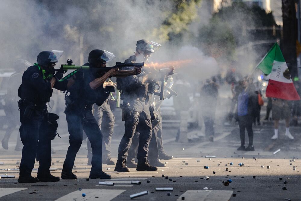 La policía lanza proyectiles durante enfrentamientos con manifestantes en el centro de Los Ángeles, durante las protestas contra las redadas de migrantes. AFP