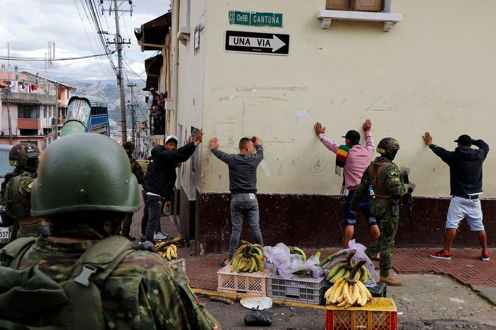 Miembros de las Fuerzas Armadas cachean a hombres durante una operación para proteger la seguridad civil en Quito. FOTO: AFP