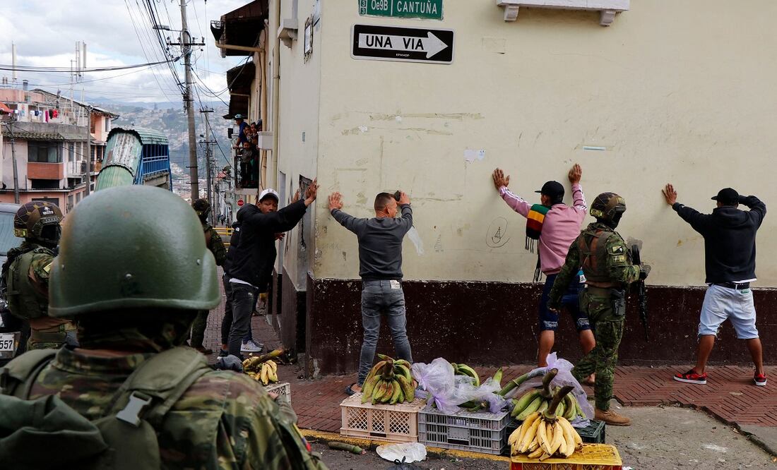Miembros de las Fuerzas Armadas cachean a hombres durante una operación para proteger la seguridad civil en Quito. FOTO: AFP
