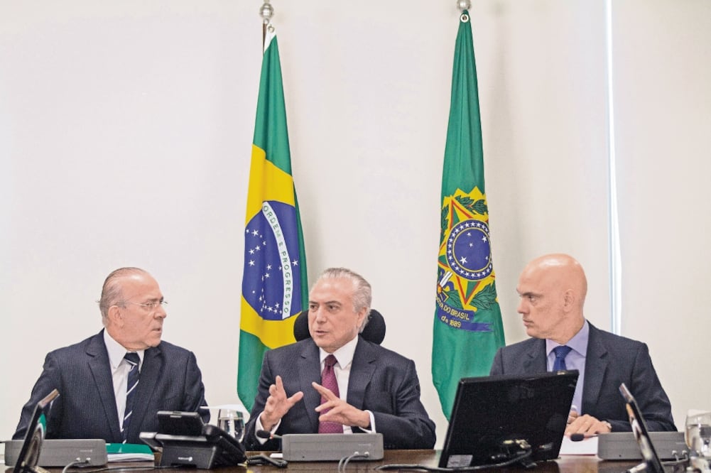 El presidente brasileño, Michel Temer, acompañado por los ministros de la Ca sa Civil, Eliseu Padilha (izq.), y de Justicia, Alexandre de Moraes (der.), ayer, en Brasilia (EDSON ALVES. EFE)