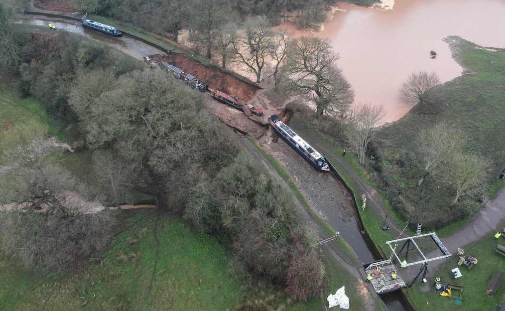 Esta foto aérea, tomada y difundida por el Servicio de Bomberos y Rescate de Shropshire el 22 de diciembre de 2025, muestra embarcaciones en el lecho del canal tras la formación de un socavón a lo largo del Canal de la Unión de Shropshire, que drenó el agua, en la zona de Chemistry de Whitchurch, Shropshire, en el centro de Inglaterra. Foto: AFP