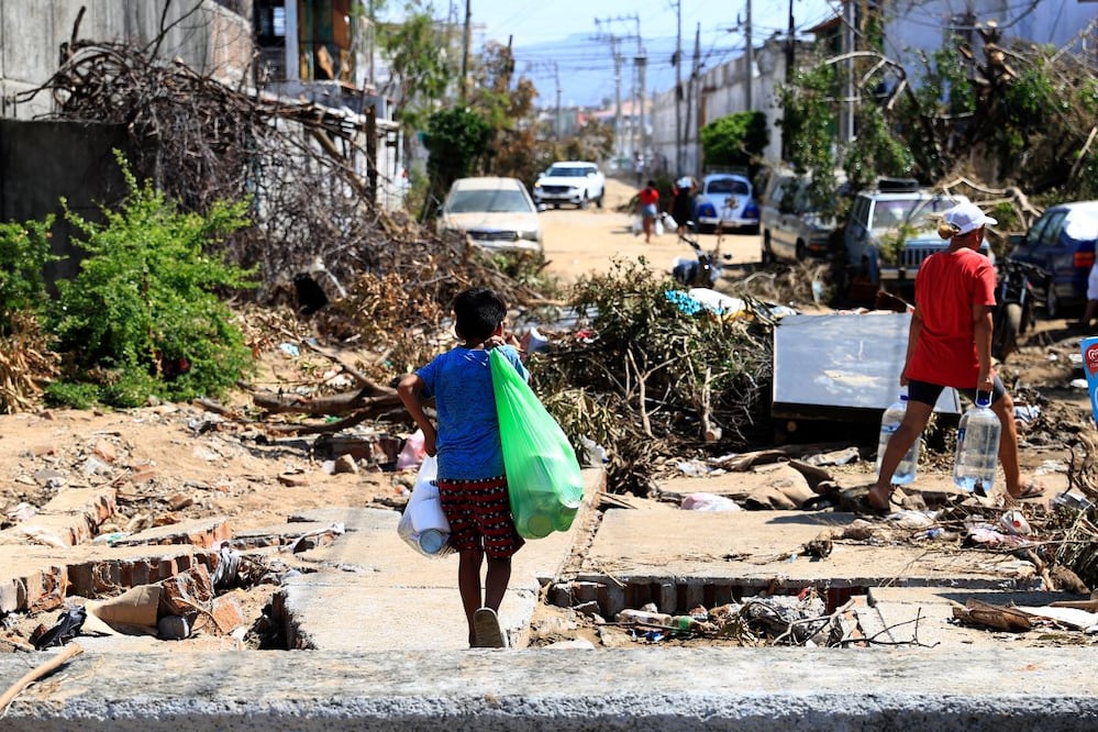 Damnificados caminan entre los escombros, en una de las zonas afectadas por el paso del huracán Otis, en el balneario de Acapulco, en el estado de Guerrero. FOTO: EFE