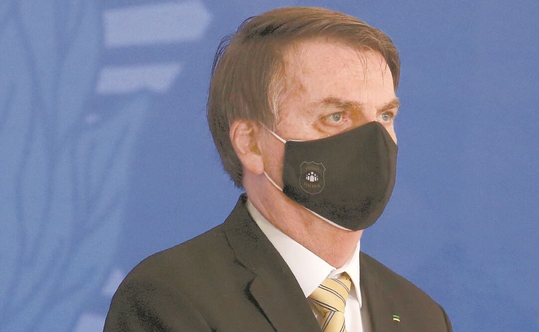El presidente de Brasil, Jair Bolsonaro, escucha el himno nacional de su país en un evento gubernamental ayer en Brasilia. Foto: ERALDO PERES. AP