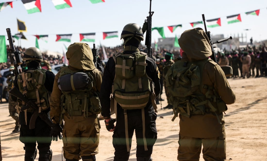 Los combatientes palestinos de Hamas aseguran un área antes de entregar rehenes israelíes a un equipo de la Cruz Roja en Khan Yunis, en el sur de la Franja de Gaza. Foto: AFP